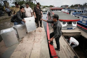 Indonesian officials load ballot boxes into a boat in Banda Aceh on Tuesday. Indonesians vote today in the country’s most pivotal presidential election since the downfall of dictator Suharto, with Jakarta governor Joko Widodo and an ex-general with a chequered human rights record in a tight race. AFP PHOTO