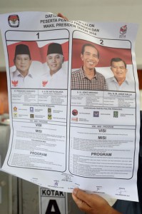 An Indonesian official holds a poster featuring Indonesian presidential candidates and their running mates Joko Widodo and Jusuf Kalla (right) and Prabowo Subianto and Hatta Rajasa (left) at a local election office in Jakarta on Monday. AFP PHOTO