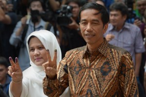Indonesian presidential candidate Joko Widodo and his wife Iriana Widodo gesture after voting at a polling center in Jakarta on Wednesday. Widodo is up against ex-general Prabowo Subianto in the polls. AFP PHOTO