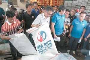 Interior Secretary Mar Roxas 2nd and Presidential Assistant for Food Security and Agriculture Francis “Kiko” Pangilinan inspect bags of rice stored at a warehouse in Muntinlupa City. The company was found to have mixed NFA rice with commercial rice. PHOTO BY EDWIN