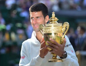 Serbia’s Novak Djokovic holds the winner’s trophy after beating Switzerland’s Rodger Federer in the men’s singles final match during the presentation on Day 13 of the 2014 Wimbledon Championships at The All England Tennis Club in Wimbledon, southwest London. AFP PHOTO