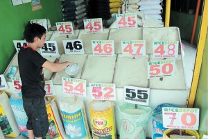  A store helper arranges rice that ranges from P42 to P57  per kilo in a Rice Store in Holy Spirit, Quezon City. President Aquino in his SONA on July 28 said the government will import commercial rice to fight rice hoarders that cause the continuous price hike of the Filipinos staple food.  PHOTO BY RUY MARTINEZ 