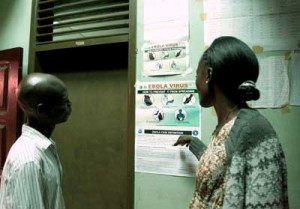 Liberian people read an information sign about Ebola set on a wall of a public health center on Friday in Monrovia. Liberia announced on Thursday it was shutting all schools and placing “non-essential” government workers on 30 days’ leave in a bid to halt the spread of the deadly Ebola epidemic raging in West Africa. AFP PHOTO