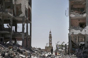 Two Palestinians walk between destroyed buildings hit three weeks ago by Israeli military strikes in the northern Gaza Strip city of Beit Hanun on Sunday. Israel and Hamas looked unlikely to end their deadly face-off even after Egypt called for an indefinite ceasefire and new truce talks. AFP PHOTO