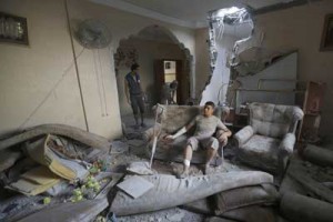 An injured Palestinian man sits inside his house after it was hit by an Israeli military strike in the Jabalia refugee camp, in the northern Gaza Strip, on Sunday. AFP PHOTO