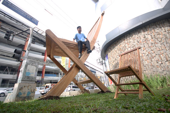  A man sits on a huge chair displayed in front of an establishment along E. Rodriquez Ave. in Quezon City. PHOTO BY MIGUEL DE GUZMAN 