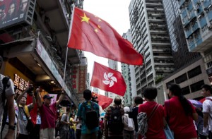 People hold the Chinese and Hong Kong flags as they take part in a pro-government rally in Hong Kong on Sunday. AFP PHOTO