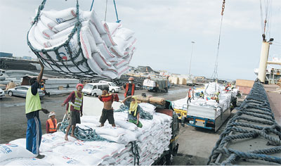 Workers unload 13 MT of imported rice from Vietnam, at the Manila Harbor Center. PHOTO BY RENE H. DILAN