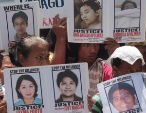 Families of victims of extra-judicial killings hold pictures of their loved ones during a protest rally in front of the National Bureau of Investigation building where retired Maj. Gen. Jovito Palparan is detained. PHOTO BY RUY MARTINEZ