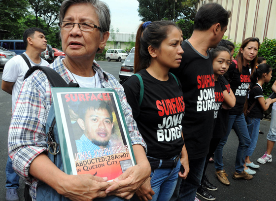 Editha Burgos clutches a photo of her son, Jonas Burgos, as families of desaparecidos mark the International Day of the Disappeared on Saturday at the University of the Philippines in Diliman, Quezon City. PHOTO BY MIKE DE JUAN