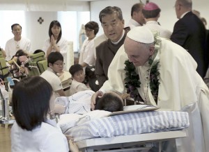 Pope Francis comforts a disabled woman during his visit to a rehabilitation center for people with disabilities at Kkottongnae in Eumseong, South Korea where he beatified 124 Korean martyrs. AFP PHOTO