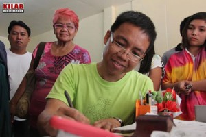 Professor Kim Gargar (center) signing a document before he was released on bail. PHOTO COURTESY OF KILAB MULTIMEDIA