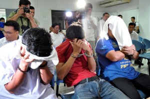  the three men arrested for allegedly assembling explosives at the ninoy aquino international airport cover their faces during inquest proceedings on tuesday at the Justice department. PHoto By eDwiN muli 