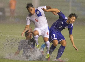  Jason De Jong (No. 6) of the Philippines is tackled by Chiu J-Huan (right) and Weng Wei-Pin (left) of Taiwan during their rain-drenched game on Wednesday night.  AFP PHOTO