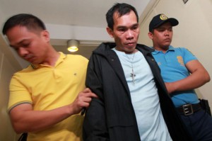  Police Sr. Insp. Allan Emlano, one of the policemen accused of robbing two men along EDSA, is escorted by policemen after he surrendered to the Quezon City Police District on Wednesday. PHOTO BY MIGUEL DE GUZMAN 