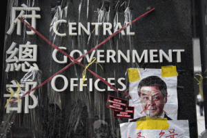 The sign for the Hong Kong central government offices is seen crossed out with red tape by democracy activists, next to a defaced image of Hong Kong’s Chief Executive Leung Chunying on Sunday. AFP PHOTO