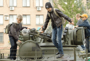 Children stand on an armored vehicle in the town of Soledar in the Donetsk region on September 27, 2014. Some 70 representatives of the Russian military under the command of Russian ground forces Lieutenant General Alexander Lentsov are in eastern Ukraine for separate meetings with Ukrainian forces and the pro-Russian rebels to talk about establishing ceasefire conditions in the region. AFP PHOTO