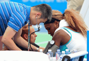 Medical personnel treat Serena Williams (right) during her match against France’s Alize Cornet at Wuhan Open tennis tournament in Wuhan, in China’s Hubei province on Wednesday. Top seed Serena Williams had to be helped from the court as she retired ill during her first set at the inaugural Wuhan Open in China. AFP PHOTO