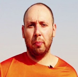 An image grab taken from a video released by the Islamic State and identified by private terrorism monitor SITE Intelligence Group on Wednesday shows 31-year-old US freelance writer Steven Sotloff dressed in orange and on his knees in a desert landscape speaking to the camera beside a masked militant (right). AFP PHOTO