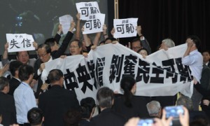 This handout photo shows pro-democracy lawmakers and protesters unfurling anti-Beijing banners inside the Hong Kong government complex as Li Fei (not pictured), a member of the top committee of China’s rubber stamp parliament, delivers his address in Hong Kong on Monday. The senior Chinese official was heckled by angry protesters as he defended Beijing’s landmark decision to control which candidates can stand in the city’s next leadership election. AFP PHOTO