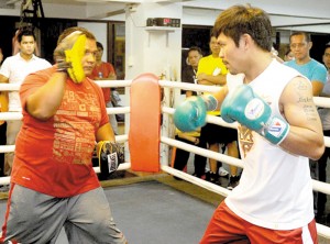 Manny paquiao (right) hits the mitts with his long time friend and trainer Buboy Fernandes