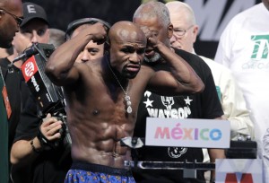 Floyd Mayweather Jr. of the US removes his jewelry before weighing in for his fight with Marcos Maidana of Argentina (out of frame) during their weigh-in at The MGM Grand on September 12, 2014 in Las Vegas.  The fighters will meet September 13, 2014  at the MGM Grand Garden Arena in Las Vegas, Nevada for  Mayweather's WBA Welterweight Belt and WBC Welterweight and Super Welterweight World Titles.    AFP PHOTO 