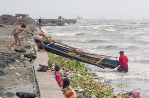 Fishermen in Baseco, Tondo, Manila, move their boat to higher ground and away from waves that will be whipped up by Typhoon Luis. PHOTO BY EDWIN MULI