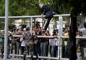 OVER THE FENCE  Marc Susselbeck, the German boyfriend of Jeffrey Laude, climbs on Wednesday the gate of Camp Aguinaldo where US Marine Joseph Scott Pemberton is detained. AFP PHOTO 