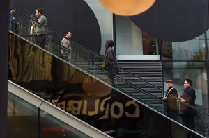 Shoppers use an escalator at a shopping mall in Beijing on Wednesday. The global economic recovery is beset by 