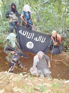 CAPTIVE:Latest photo posted by Aboo Rami on his Twitter account shows German Stefan Viktor Okonek and members of the Abu Sayyaf holding him hostage in Sulu.