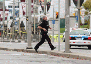 QUICK RESPONSE  An Ottawa police officer runs across Wellington Street, near the National War Memorial where a soldier was shot and killed earlier in the day, just blocks away from Parliament Hill, on October 22, in the Canadian capital. AFP PHOTO