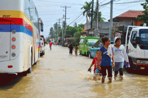 AFTER THE RAIN Residents walk on a flooded street after a heavy downpour on Saturday in Sultan Kudarat. PHOTO BY MOH I. SAADUDDIN