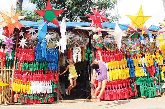 Children leap to touch christmas lanterns displayed along roxas blvd. in Pasay city. lanterns and other christmas décor have become ubiquitous more than a month before the holidays. PHoto By Ruy l. Martinez