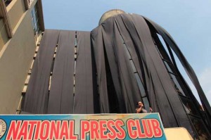 MASSACRE ANNIVERSARY  National Press Club (NPC) President Joel Egco unfurls black drapes at the facade and spiral staircase of the NPC building in Manila to start the weeklong observance of the fifth anniversary of the Ampatuan Massacre. PHOTO BY RUY MARTINEZ