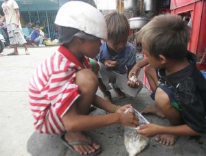 SHARING FOOD Street children share food donated by a restaurant in downtown Cebu City.the government will spend P568.6 billion or 32 percent of the P1.816- trillion national budget to combat poverty. Photo By Ruy Martinez