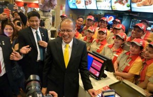 JOLLY MOMENT President Benigno Aquino 3rd lines up at the counter of Filipino fastfood chain Jollibee in Singapore.  AFP PHOTO/STRAITS TIMES 