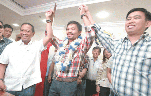 BINAYS FOR PACMAN  Vice President Jejomar Binay and Makati Mayor Jejomar Erwin Binay raise the hands of Sarangani Rep. Manny Pacquiao. The boxing champ was given a hero’s welcome at the country’s financial district following his impressive victory over Chris Algieri on Sunday. PHOTO BY RENE H. DILAN