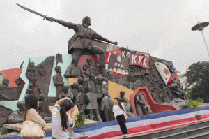REVOLUTIONARY HERO  Foreigners take souvenir photos at the Bonifacio Shrine in Manila on Saturday, a day before the commemoration of the revolutionary hero’s 151st birth anniversary. PHOTO BY RUY MARTINEZ