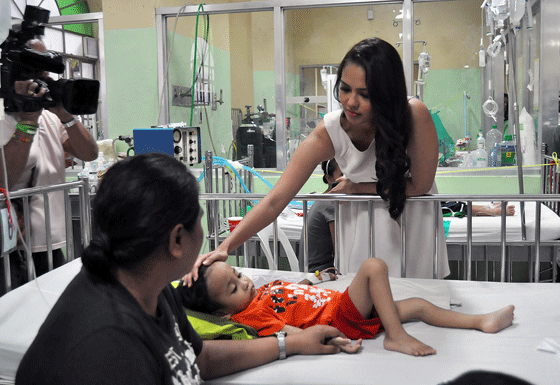 Miss World 2013 Megan Young reaches out to touch a sick child in a pediatric ward at the Philippine General Hospital during her visit Tuesday. Young visited the soon-to-be completed P5 million PGH wing dedicated to terminally ill and cancer stricken children, using the fund that was raised by Miss World’s Beauty With a Purpose program. PHOTO BY EDWIN MULI