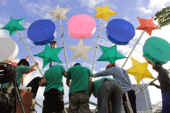 Rizal Park personnel install colorful lanterns on Saturday. PHOTO BY RUY MARTINEZ