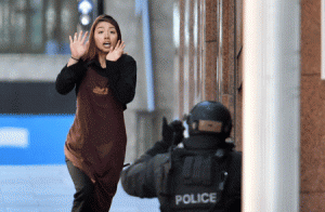 SUCCESSFUL ESCAPE  One of the hostages runs toward police from a cafe in the central business district of Sydney on Monday. Five people ran out of a Sydney cafe where a gunman has taken hostages and displayed an Islamic flag against the window, witnesses and police said. AFP PHOTO