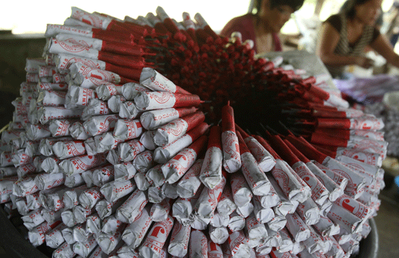 A pile of baby dynamites is seen near workers at a firecracker factory in Bocaue, Bulacan. Firecracker-related injuries are expected to rise because many Filipinos prefer to greet the New Year with fireworks. PHOTO BY RENE H. DILAN