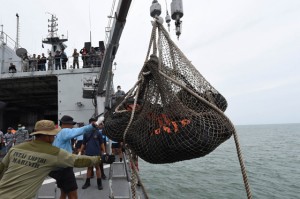 GRIM TASK Indonesian navy personnel watch as bags containing dead bodies are lifted onboard indonesian navy vessel ‘kri Banda aceh’ during search operations for airasia flight Qz8501 in the java sea. AFP PhOTO 