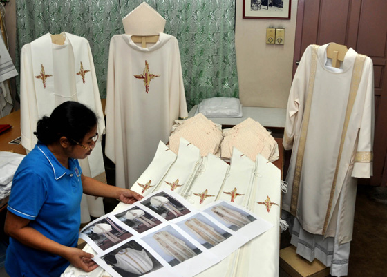 A worker at Talleres de Nrzaret in Quezon City shows the different chasubles especially made for Pope Francis and the bishops and priests who will concelebrate Mass at the Rizal Park. PHOTO BY MIKE DE JUAN 