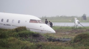 Airport staff check the private plane that overshot the runway of the Tacloban airport in Tacloban on Saturday. All passengers, which included top Palace officials, were shaken but safe. AFP PHOTO 