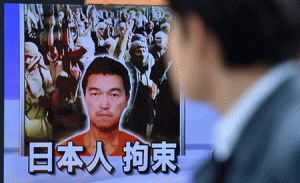 FACING A CRISIS  A pedestrian looks at a TV screen in Tokyo on Monday showing news reports about Japanese journalist Kenji Goto being held by Islamic militants. The Islamic State group has said it executed one of two Japanese hostages it has been holding, in an apparent beheading that has been slammed by leaders around the world. AFP PHOTO