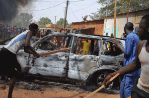 UNREST OVER ‘CHARLIE’  People hold wooden sticks next to damaged cars during a demonstration on Sunday in Niamey, Niger against French weekly Charlie Hebdo's publication of a cartoon of the Prophet Mohammed. AFP PHOTO 