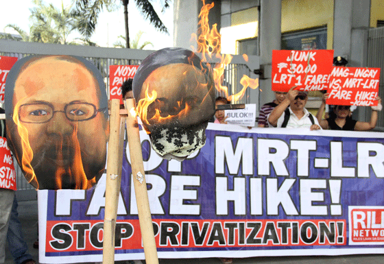 Consumers and advocacy groups burn an image of Transportation Secretary Joseph Abaya at the head office of the Light Rail Transit Authority in Quezon City on Monday to protest recent fare increases in Metro Rail Transit 3 and Light Rail Transit 1 and LRT 2. The fares were raised on January 4, despite Abaya lacking authority to do so, according to the protesters. PHOTO BY MIKE DE JUAN