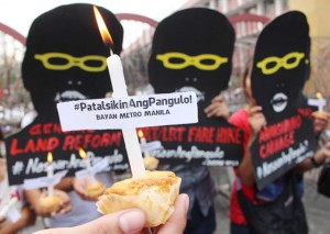 A Candle for  Aquino Members of bayan light candles during a rally at mendiola to press their call for President benigno aquino 3rd to step down because of the massacre of 44 police commandos in maguindanao.  PHoto By Ruy Martinez