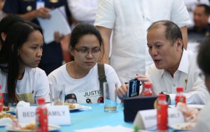 ALL EARS  President Benigno Aquino 3rd chats with relatives of some of the policemen killed in Mamasapano. MALACAÑANG PHOTO